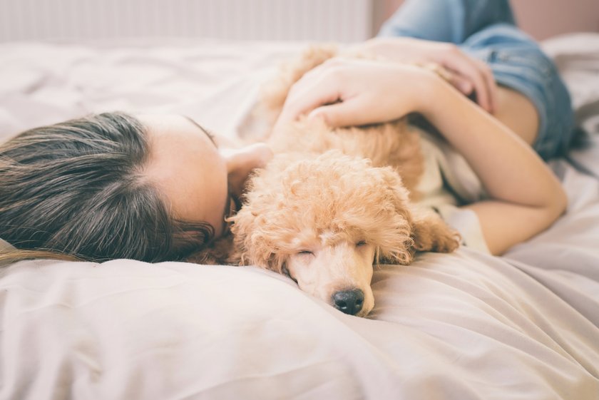 Mädchen kuschelt mit Hund