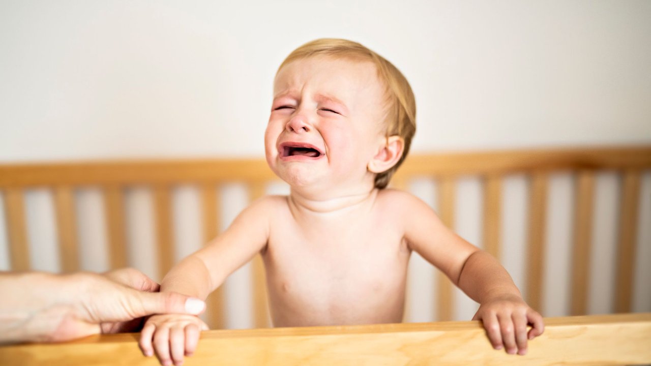 Bei der Ferber-Methode nehmen Eltern ihre weinenden Kinder nicht aus dem Bett, sondern sprechen nur beruhigend mit ihnen. 