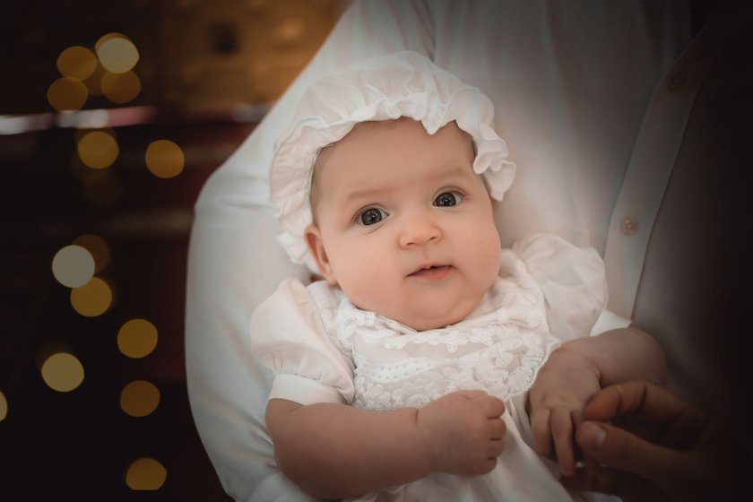 a baby in a baptismal outfit in the arms of his mother in a temple or church came to worship in an Orthodox church or baptism a baby