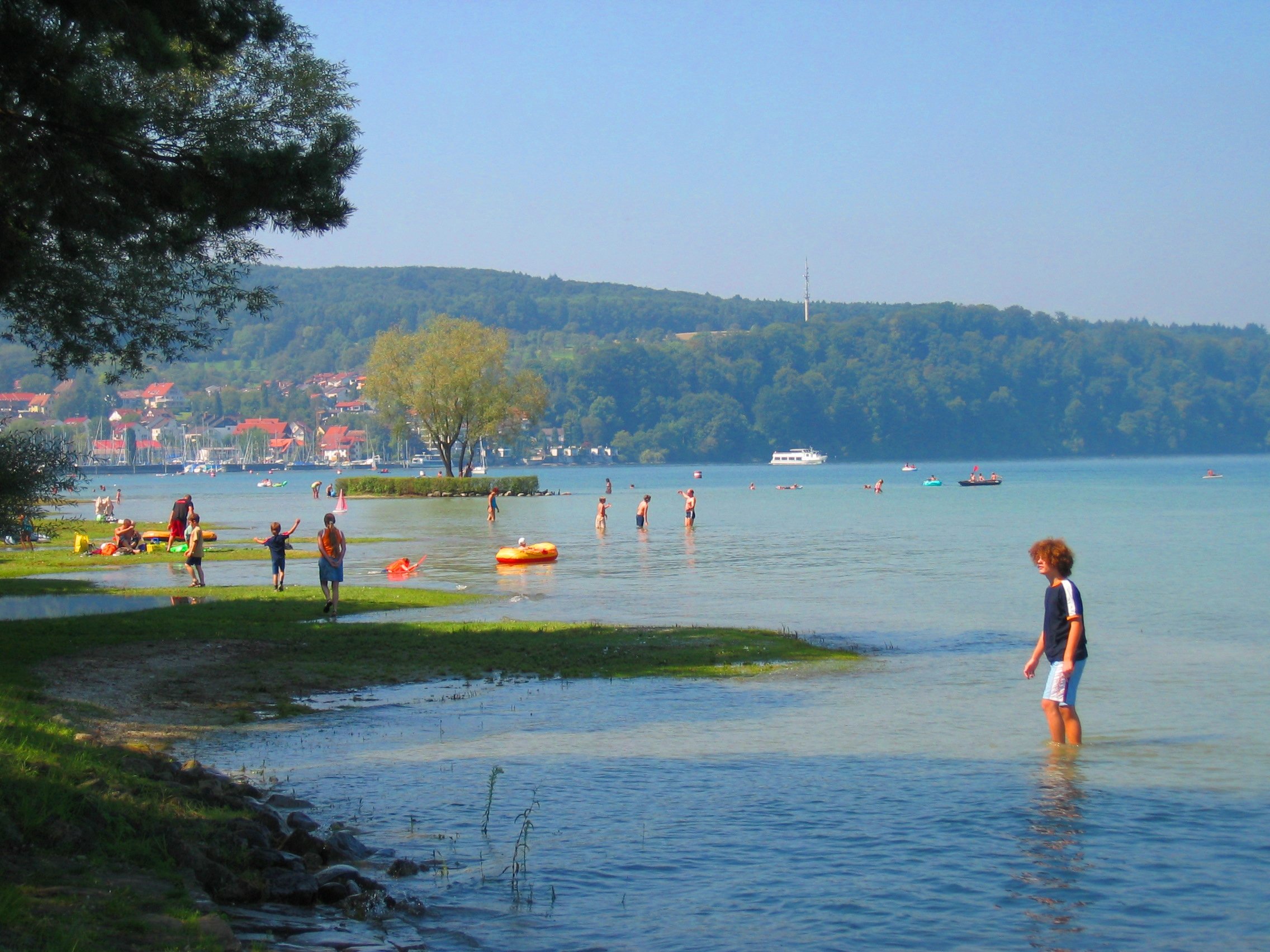 Strandbad Dingelsdorf mit Liegewiese, Strand in den Bodensee und badenden Menschen