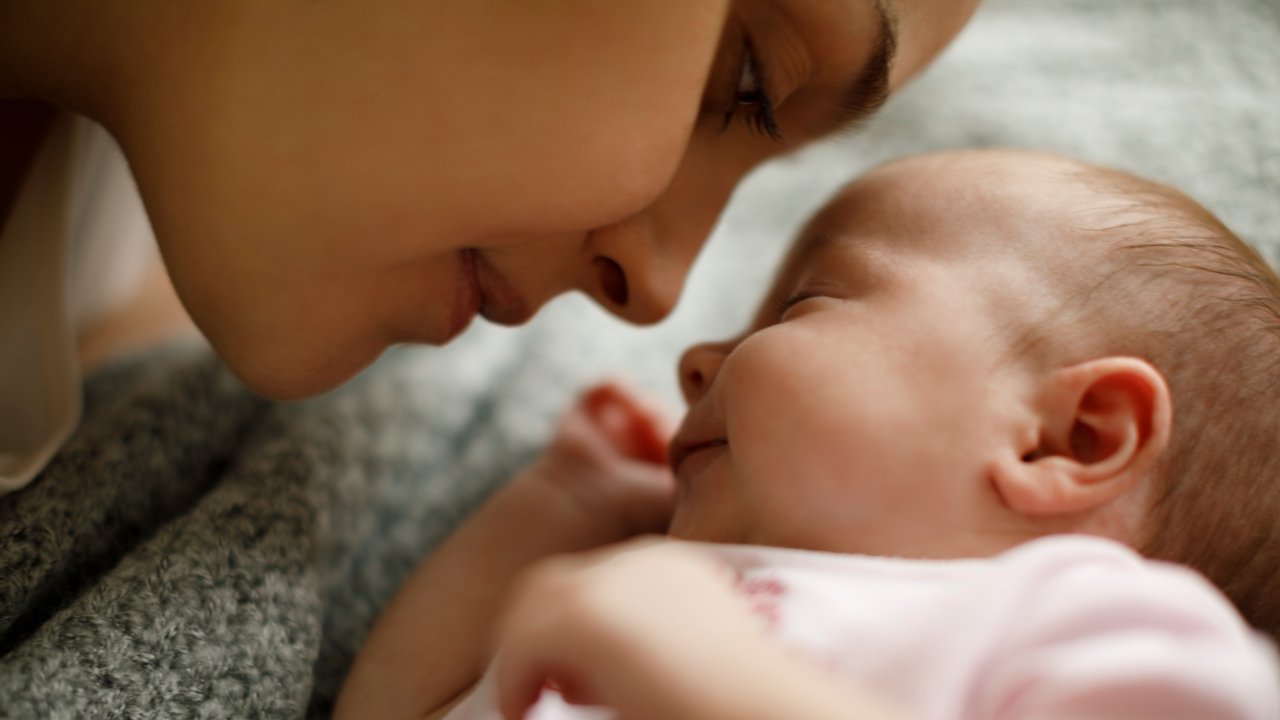Wochenbett-Dauer: Mama kuschelt mit Baby im Bett