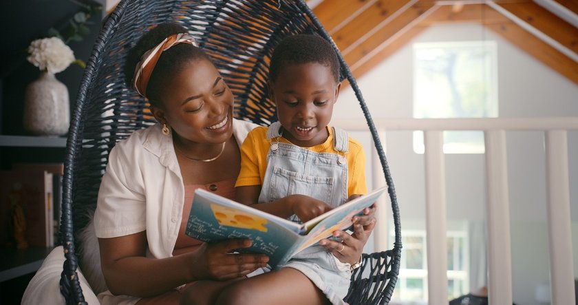 Black History Month Kinderbücher: Mama liest Kind aus Kinderbuch vor