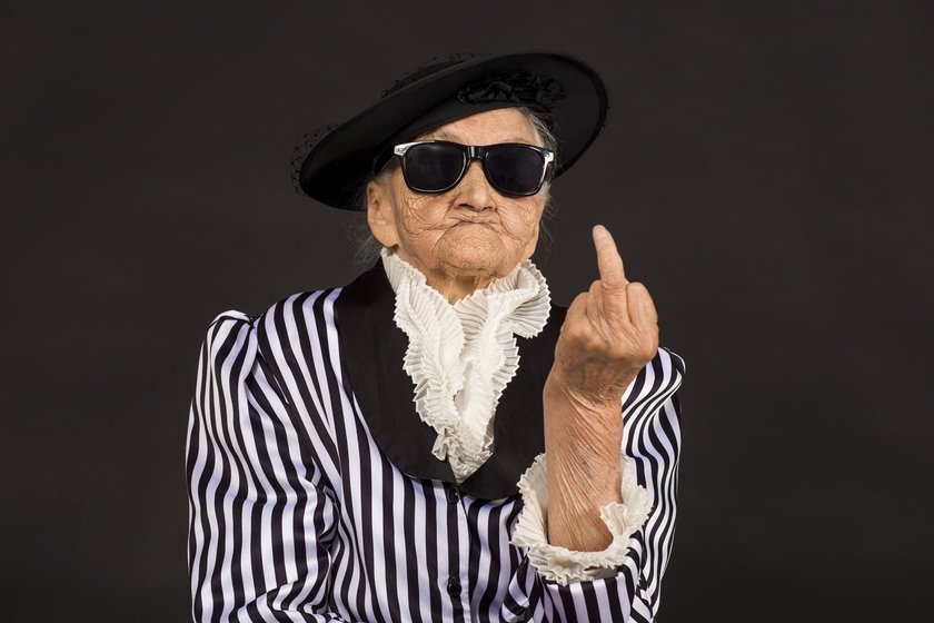 Stylish old woman in black hat with sunglasses