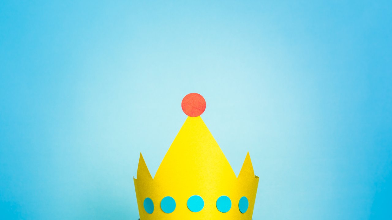 Top of the head of a woman wearing golden yellow crown. Content marketing is queen / king concept.