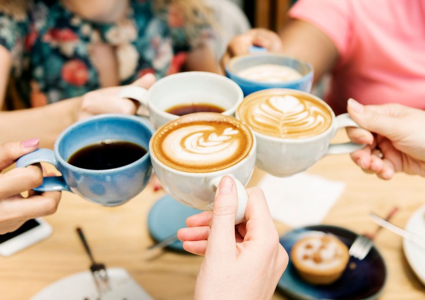 Freunde in einem Coffeeshop mit verschiedenen Tassen Kaffee