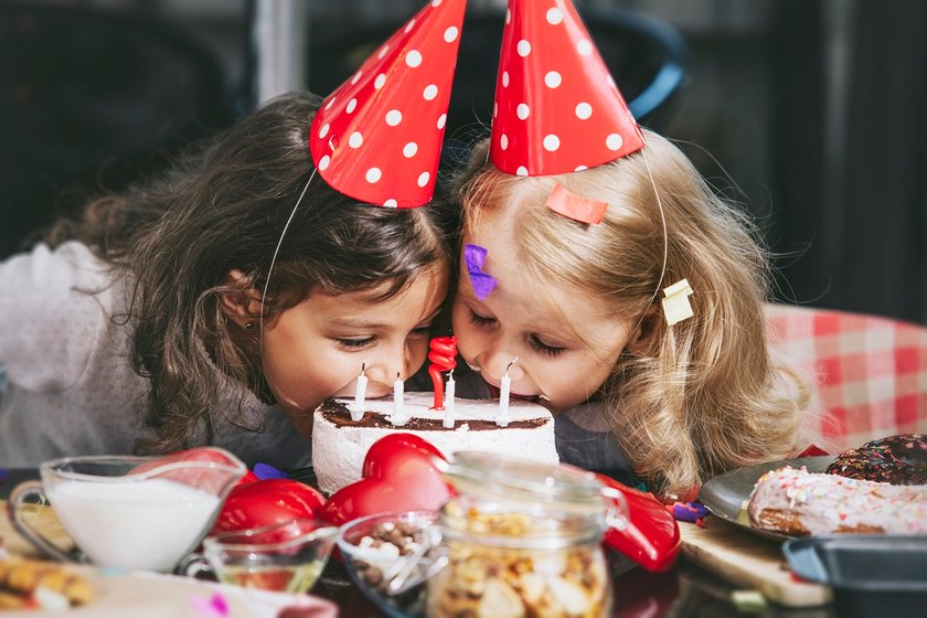 Kindergeburtstag feiern: Mädchen essen Kuchen ohne Hände
