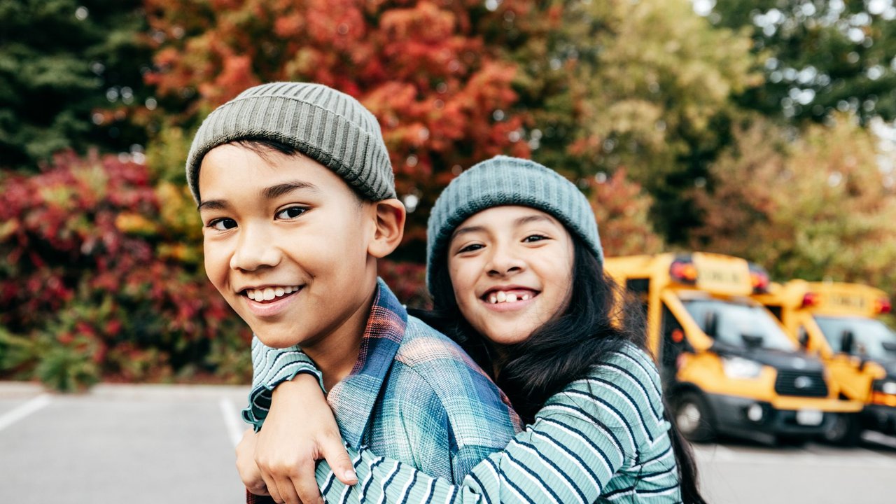 Happy siblings after school outdoors