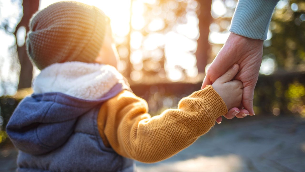 Adoption in Deutschland: Kind hält Hand einer Frau