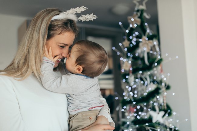 Mutter mit Baby am Weihnachtsbaum