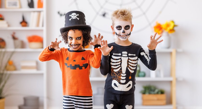 Halloween Witze: Kinder als Skelett und Grusel-Pirat verkleidet machen Grimassen