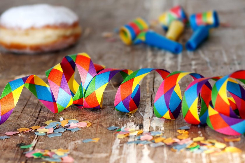 Donut im Hintergrund bunte Luftschlange auf einem Tisch im Vordergrund