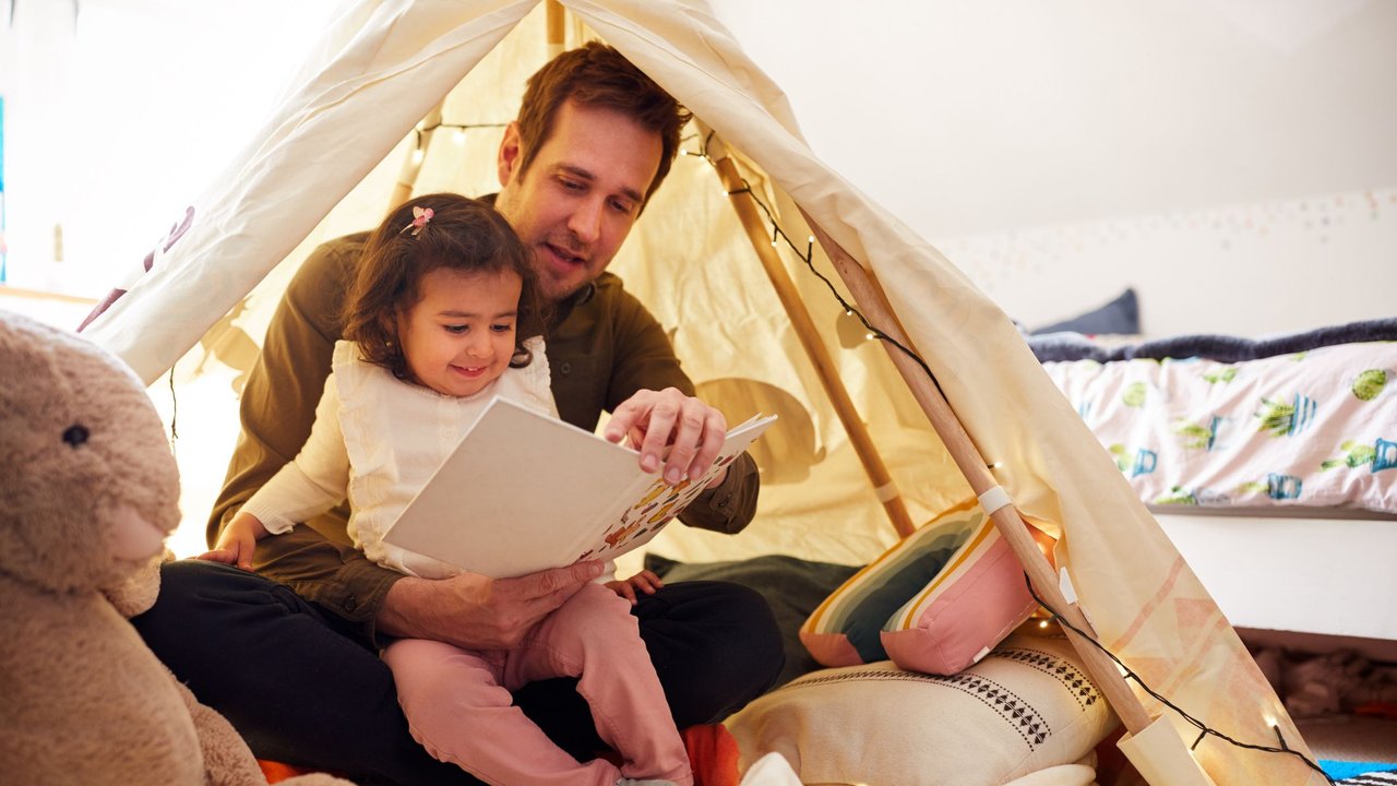 Nestmodell: Vater liest Tochter vor in Kinderzimmer-Zelt