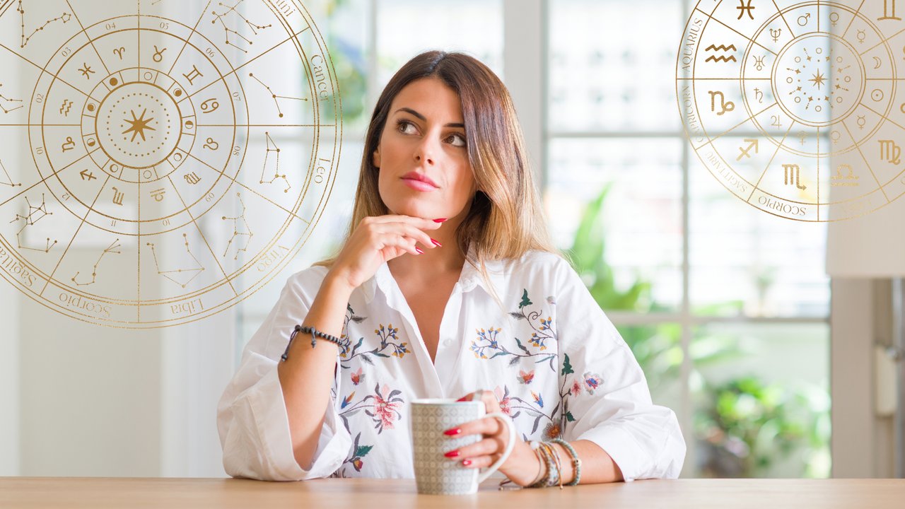 Nachdenkliche Frau sitzt mit einem Kaffee am Tisch