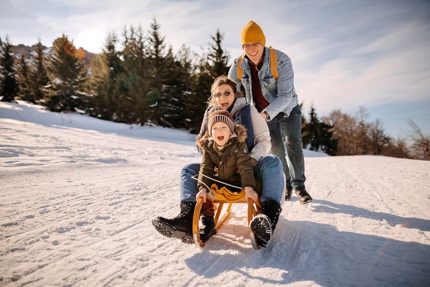 Familie fährt Schlitten im Schneee