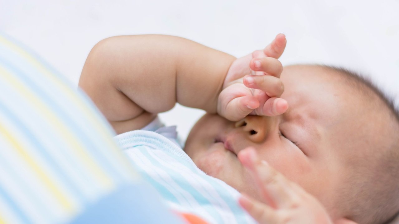 Baby reibt sich ein Auge