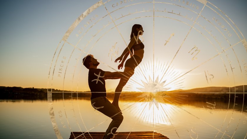 Pärchen mach Acroyoga bei Sonnenuntergang an einem See