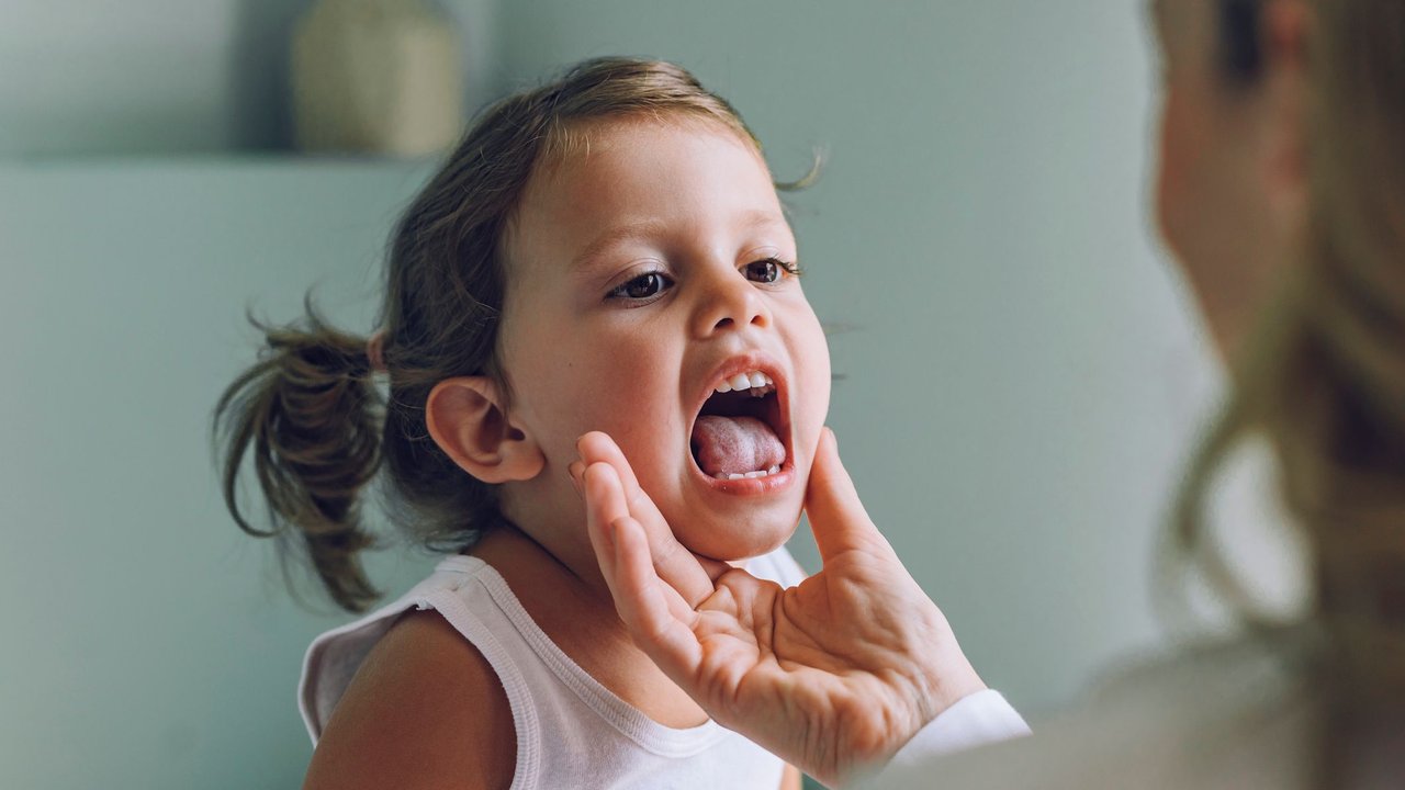 Say aaa! A doctor checking a young girl's sore throat.