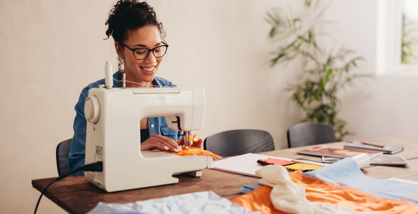 Woman sewing face mask at home. Woman using the sewing machine to sew the protective face mask.