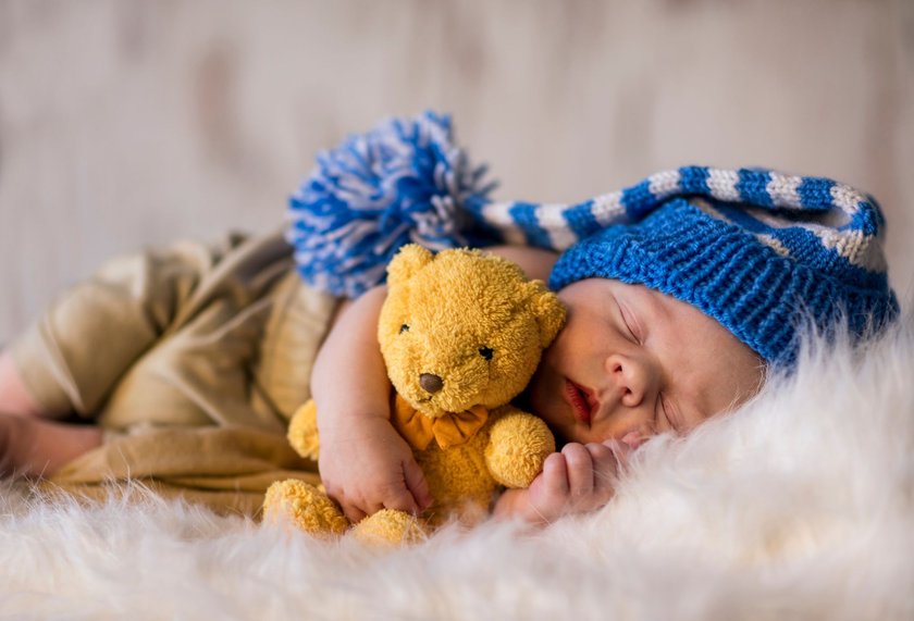 Sweet young boy sleeping with teddy bear, newborn photography