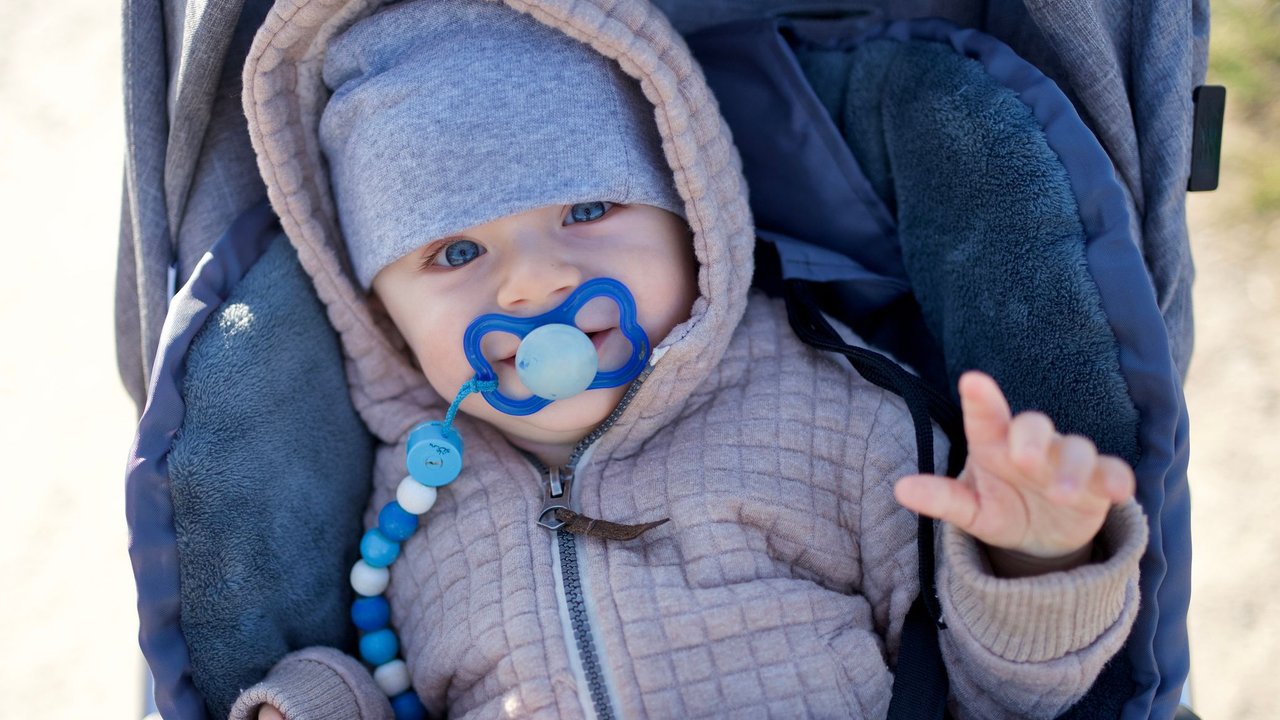 Baby mit blauen Augen im Kinderwagen