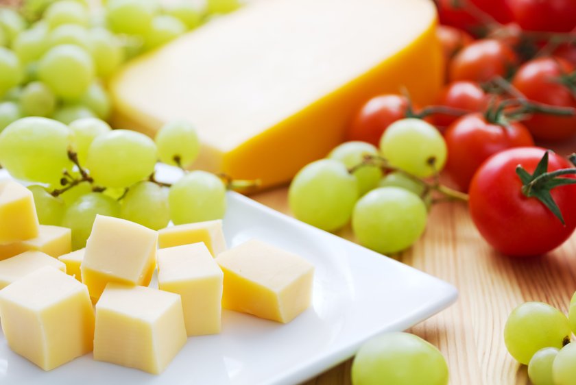 Gouda cheese snack with grapes and tomatoes.