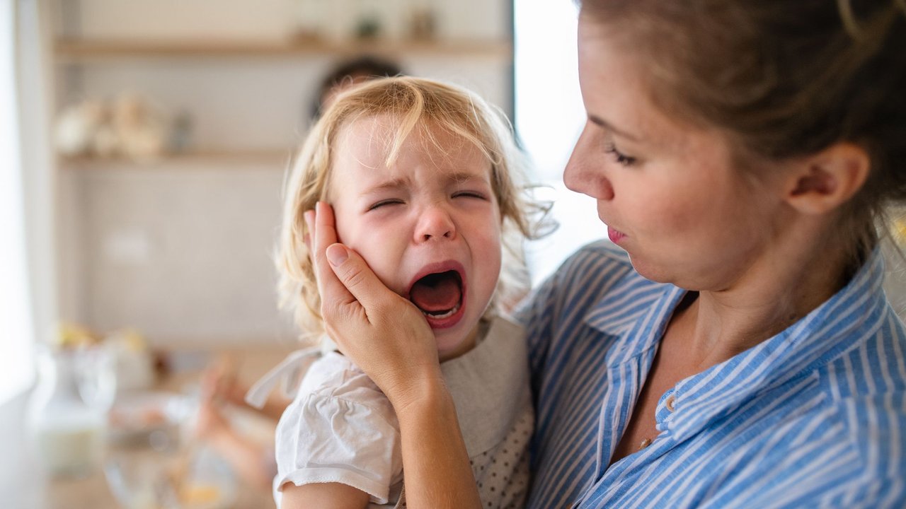 Po versohlen: Mutter tröstet weinendes Kind nach Ohrfeige