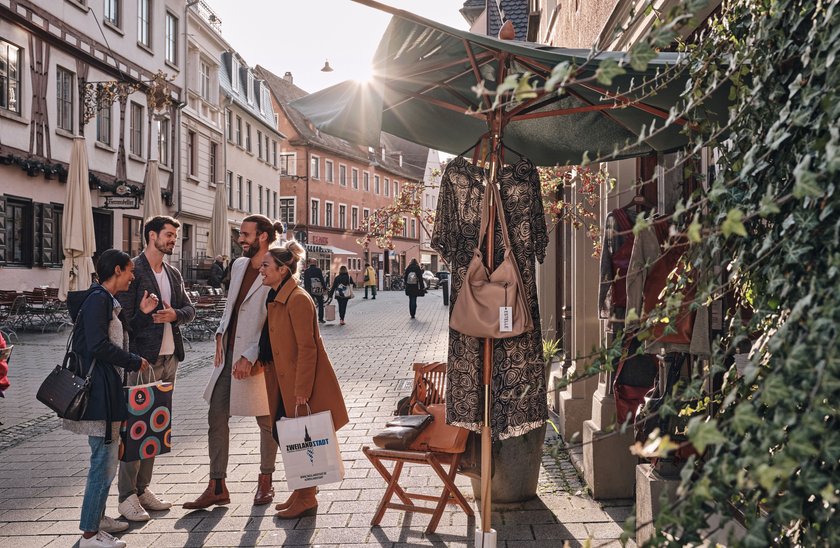 Menschen unterhalten sich beim Shoppen in der Herrenkellergasse in Ulm