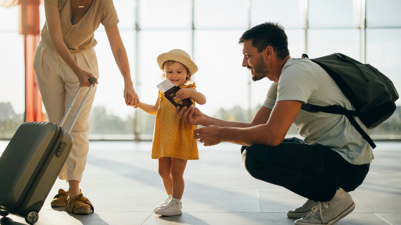 Kinderausweis: Mama, Papa, Kind am Flughafen mit Kinderausweis in der Hand