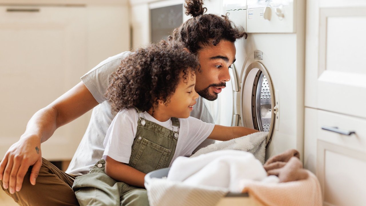 Vater mit Kind und Waschmaschine