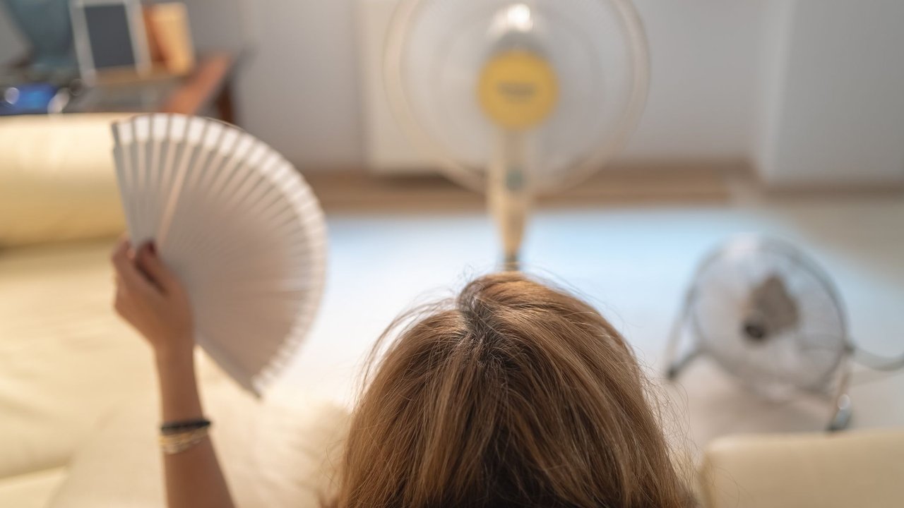 Hitzewallungen in der Schwangerschaft: Frau sitzt vor Ventilatoren