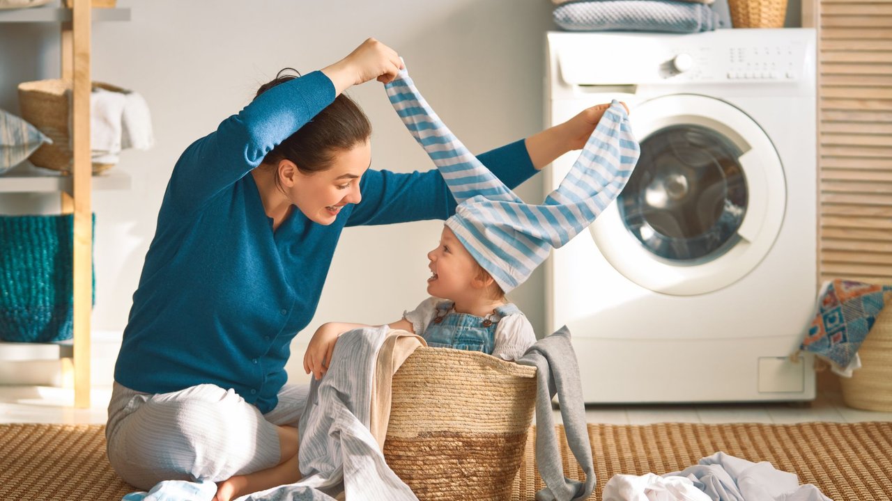 Mutter und Kind beim Wäsche waschen