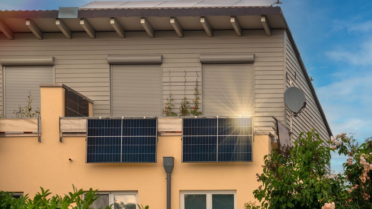 Balkonkraftwerk zur umweltfreundlichen Nutzung erneuerbarer Energien. Solaranlage auf einem Balkon mit Sonnenlichtreflexion und speziellem Lens-Flare-Lichteffekt.ChatGPT fragen