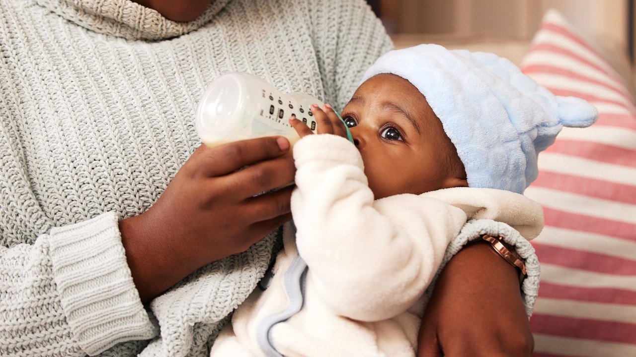 Frau füttert Baby mit Flasche