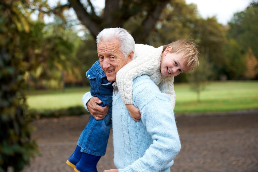 Großvater mit lachendem Enkel über den Schultern
