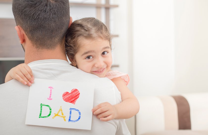 Mädchen hält Blatt mit "I love dad"