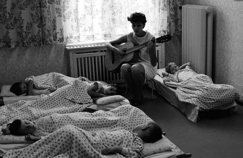07.05.1983, Berlin, Deutsche Demokratische Republik DDR - Kindergärtnerin spielt vor dem Mittagsschlaf der Kinder auf der Gitarre