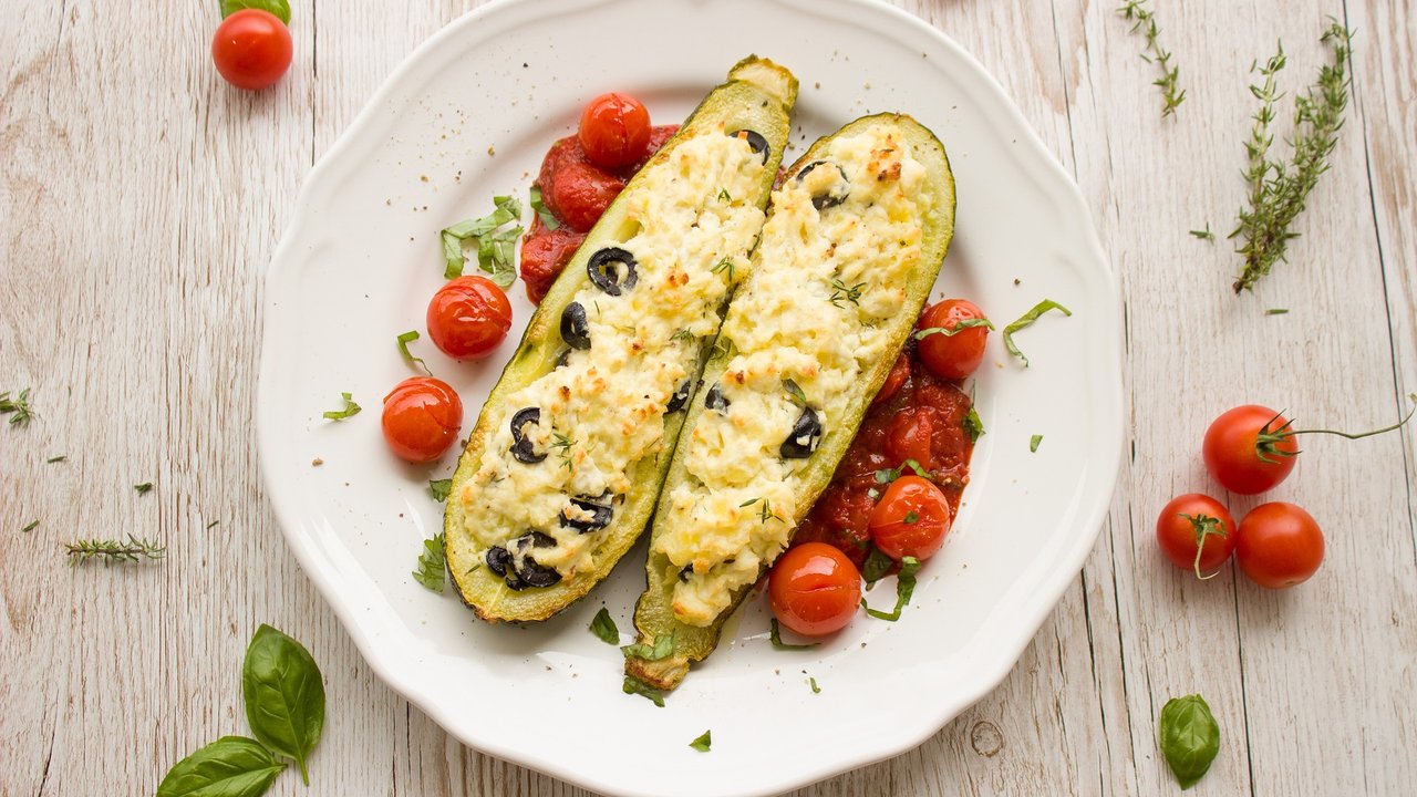 Zucchini überbacken, gewürzt mit gehackten schwarzen Oliven.