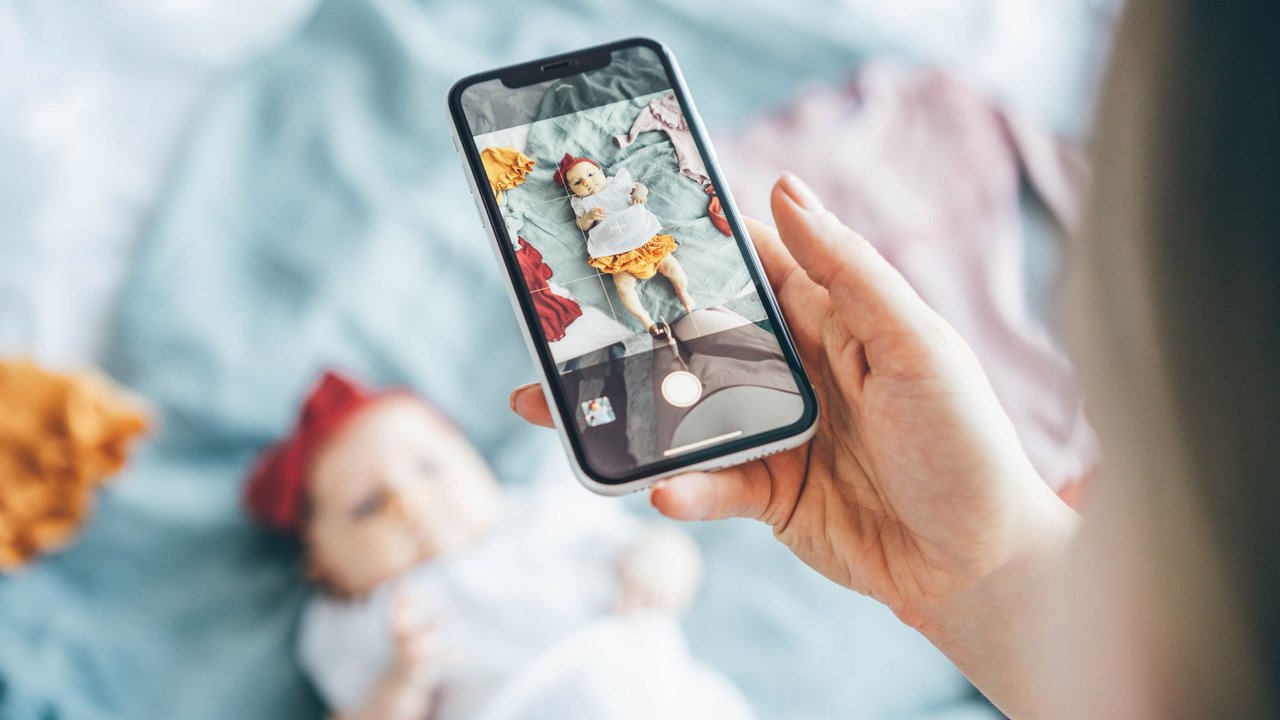 Babyshooting-Ideen: Mutter fotografiert ihr Baby mit dem Handy