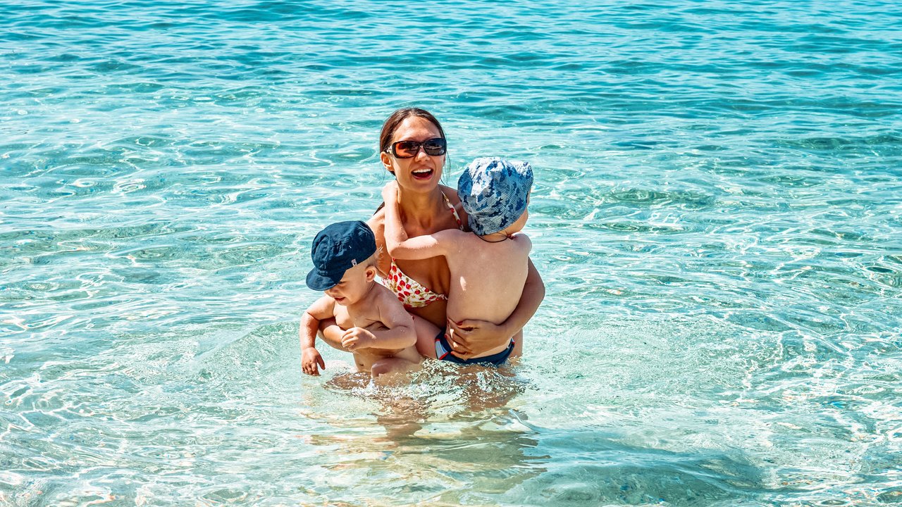 Adria mit Kindern - Frau mit Kindern im Meer