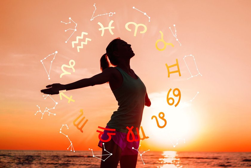 Frau am Strand mit Sternzeichen-Symbolen und Sonnenuntergang