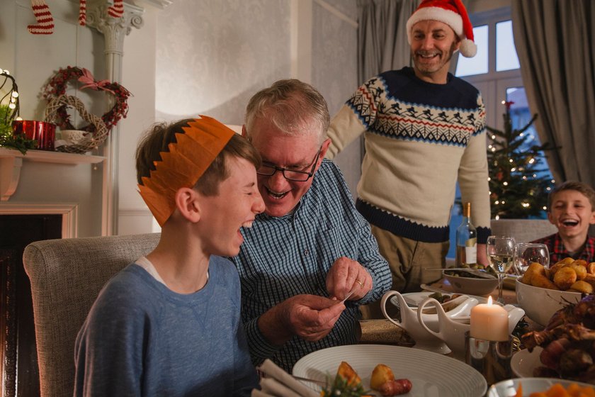 Scherzfragen für Kinder: Opa lacht mit Kindern über Witz an Weihnachten