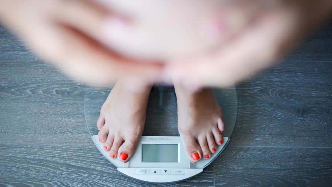 Körpergewicht und Kinderwunsch: Frau auf der Waage