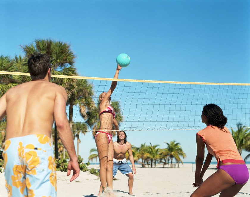Vier Menschen spielen Beachvolleyball
