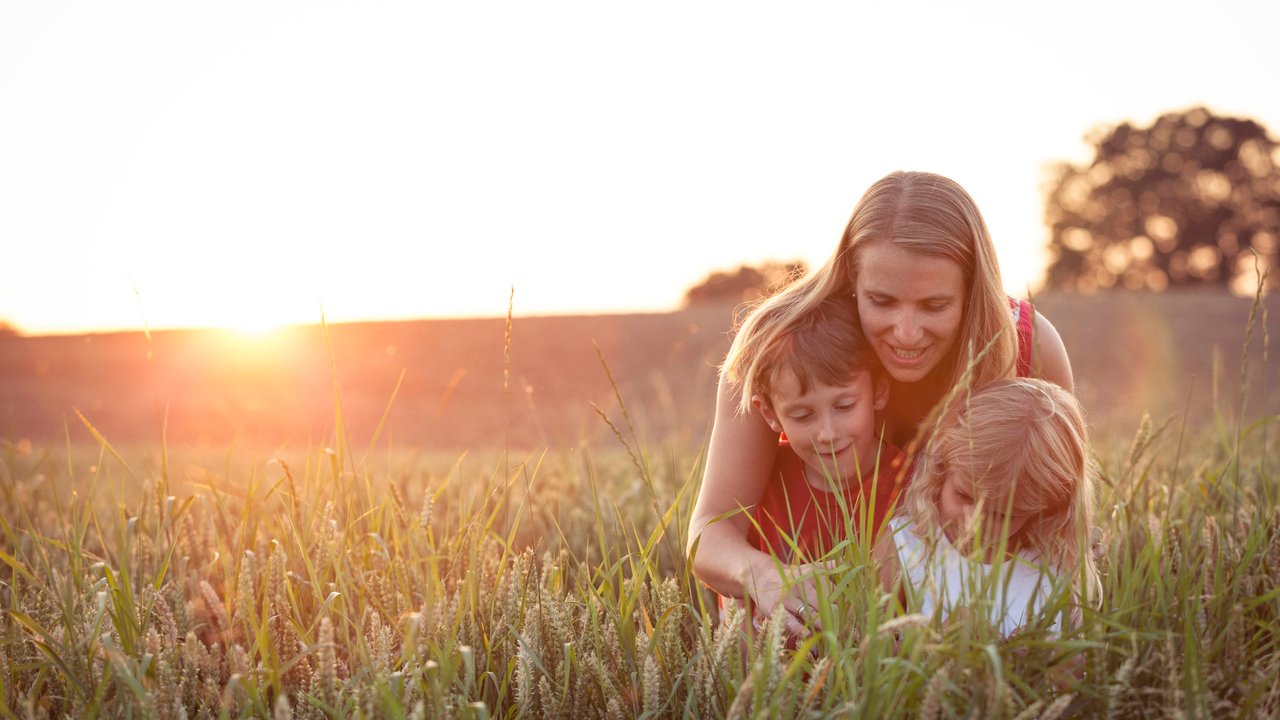 Smiling mother with son and daughter at agricultural field during sunset model released Symbolfoto WFF00530