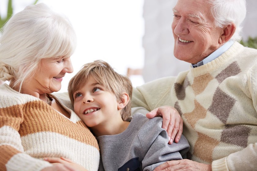 Großeltern mit lächelndem Enkel im Arm