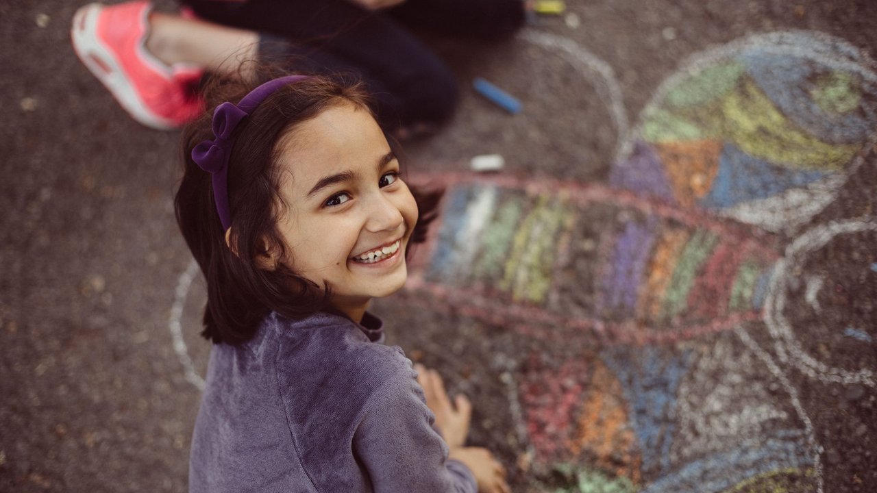 Happy kids drawing on the ground