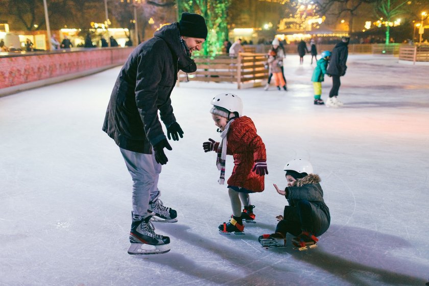 Schlittschuh laufen mit Kindern macht mit der festlichen Deko in der Vorweihnachtszeit noch mehr Spaß.