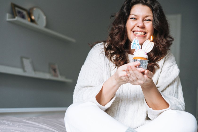 Glückwünsche zum 40. Geburtstag: Frau hält Mini-Kuchen mit 40 in der Hand