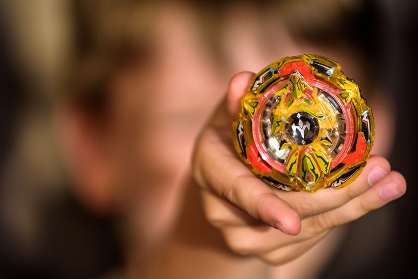 Popular kids toys. Little caucasian boy demonstrated Beyblade in his hands.