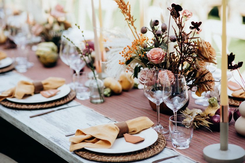 Elegante Hochzeitsdekoration mit Brauntönen, Wildblumensträußen und kleinen Zierkürbissen